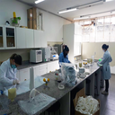 três pessoas montando protetores faciais