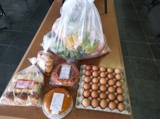 #PraTodosVerem imagem com itens da cesta dentro de um saco amarrado e de produtos de panificação (pães, bolos e biscoitos).