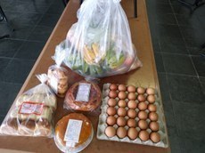 #PraTodosVerem imagem com itens da cesta dentro de um saco amarrado e de produtos de panificação (pães, bolos e biscoitos).