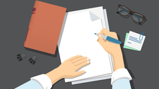 A ilustração mostra duas mãos brancas posicionadas sobre um bloco de papéis em branco sobre uma mesa cinza escura. Em torno do bloco, há um livro bege, à esquerda, bem como dois clipes. Do lado direito, um par de óculos e um pequeno bloco de anotações.