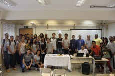 Alunos e palestrantes posam para foto em sala de aula.