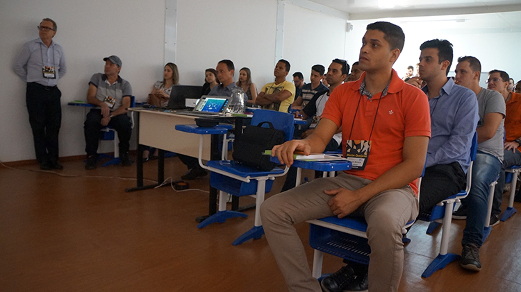 #Pratodosverem: Participantes do curso sentados em carteiras azuis, olhando para a frente.