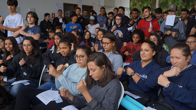 #Pratodosverem: participantes do evento olham fixamente para frente e fazem sinais de Libras.