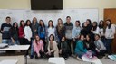 #Pratodosverem: estudantes de Alimentos participantes da Olimpíada. Um grupo está em pé e encostado no quadro branco. À sua frente, alunas agachadas.