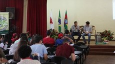 #Pratodosverem: Imagem de uma palestra do evento em 2019. O palestrante e o mediador estão no palco do Salão Nobre sentados em cadeiras. Estudantes estão sentados na plateia.