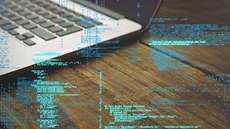#Pratodosverem: Imagem ilustrativa. À esquerda, há um computador em cima de uma mesa. Em primeiro plano, aparecem letras e números, simulando comandos de programação.