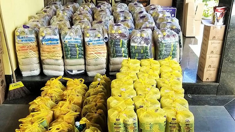 Doações #Pratodosverem: Foto das cestas básicas doadas. Materiais estão em sacos plásticos transparentes e amarelos.