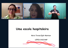 #PraTodosVerem: print de uma tela do Youtube com quatro janelas. Na parte superior, há três janelas. A da esquerda apresenta o rosto de uma mulher de óculos, cabelos presos, camisa verde xadrez; ao fundo, parede bege com um quadro; na parte inferior, um retângulo com o texto: Maria Teresa. A janela ao centro apresenta o rosto de uma mulher de cabelo preto com batom escuro; ao fundo, a parede branca com folhagens; na parte inferior, um retângulo com o texto: Bia Possato. A janela da direita apresenta uma mulher com camisa preta sinalizando em Libras; ao fundo, a parede verde; na parte inferior, um retângulo com o texto: Márcia C P Duarte. Na janela maior da parte inferior da tela, há um slide com o título: “Uma escola hospitaleira”; abaixo, há o texto: Maria Teresa Eglér Mantoan, LEPED/UNICAMP.