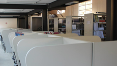 #pratodosverem: Imagem mostra parte interna da Biblioteca Acyr Loureiro Lima, do Campus Santos Dumont do IF Sudeste MG. Aparecem cabines de estudo e, ao fundo, estantes repletas de livros.