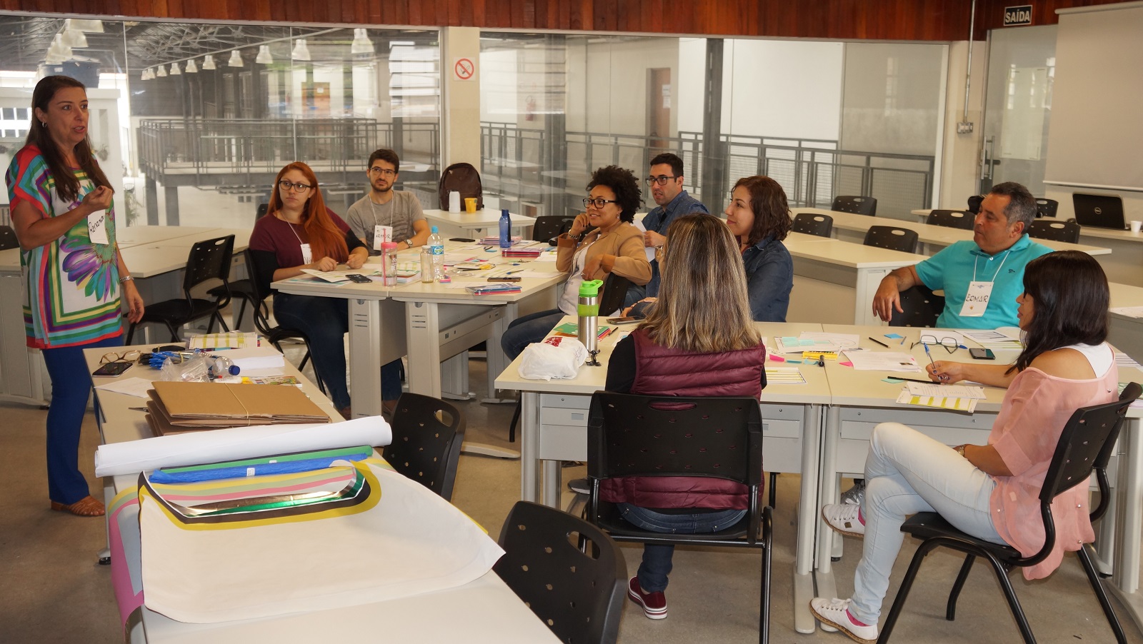 #pratodosverem: Imagem mostra consultora Ronara Adorno conversando com servidores, divididos em grupos e sentados às mesas em laboratório do Campus Santos Dumont.jpg