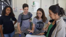 #pratodosverem: Imagem mostra três alunos e uma servidora do Campus Santos Dumont. A estudante Mirela Reis, atendida pela pedagoga Elisângela Moraes, faz o cadastro biométrico