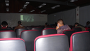 #pratodosverem: Imagem mostra pessoas assistindo a um dos curtas-metragens da última ação do Cine Neabi em 2022, no Auditório do Campus Santos Dumont.