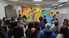 #pratodosverem: Imagem mostra estudantes do Partiu IF em frente a mural artístico na Biblioteca Acyr Loureiro Lima, durante guiamento conduzido por alunos do curso técnico em Guia de Turismo