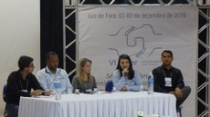 Imagem mostra mesa-redonda da edição de 2016 do Sisfer, realizada em Juiz de Fora (MG). Aparecem sentados, da esquerda para a direita, os professores Philipe Pacheco e Marcus Vinícius de Paiva, a técnica de laboratório Adriana Gerheim, a técnica em Transporte Ferroviário Laís Machado (que fala ao microfone) e o professor Sandro Baldo. Ao fundo, aparece um banner do evento.