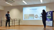 #pratodosverem: imagem com os estudantes Felipe e Bianca apresentando a pesquisa.