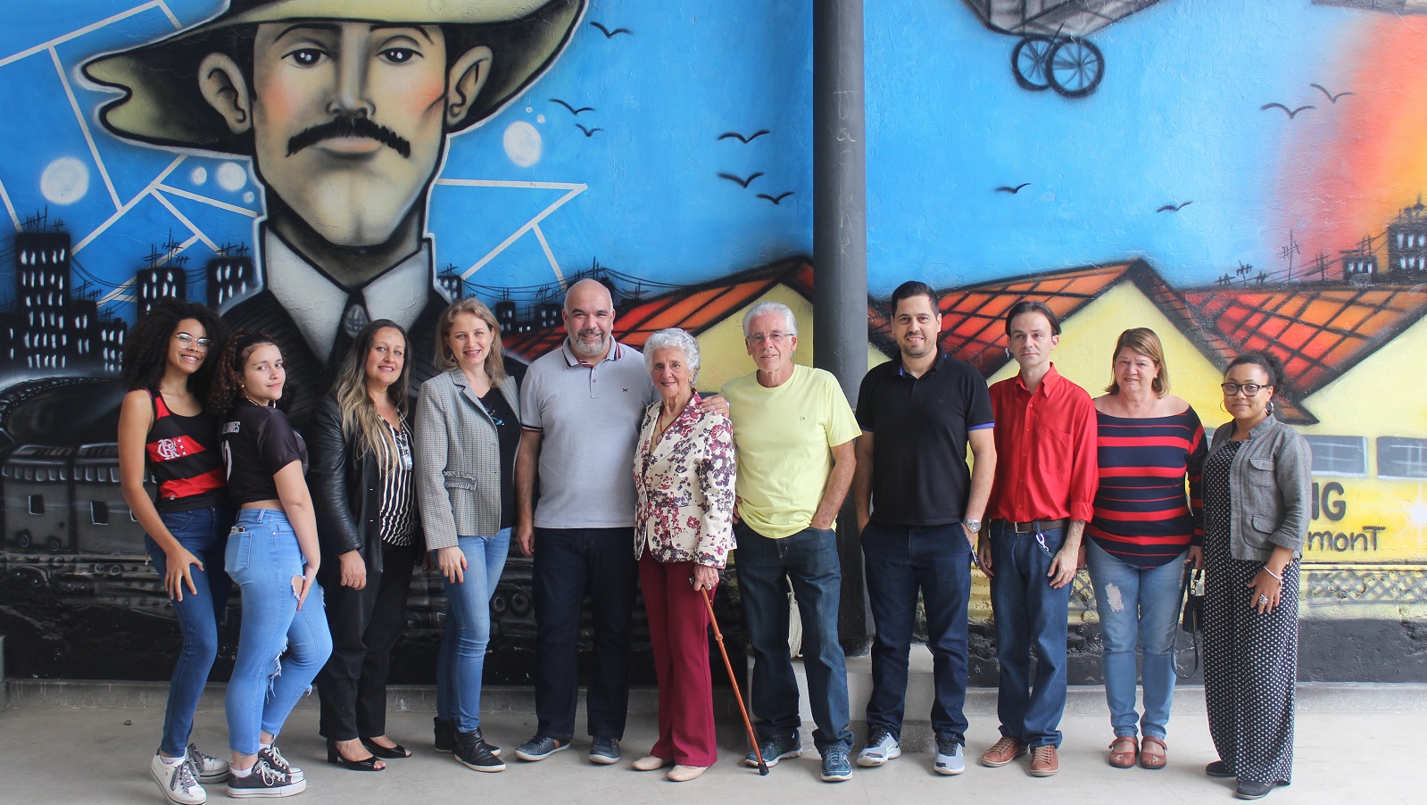Familiares de Acyr Loureiro Lima, apoiadores da campanha e servidores do IF Sudeste MG em frente ao Mural Artístico do Campus Santos Dumont