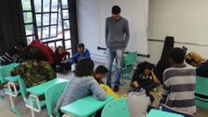 #pratodosverem: Imagem mostra os alunos Gabriel Correa e Milton Junior, da Licenciatura em Matemática, conduzindo uma atividade do Pibid, de aprendizado por meio de jogos, com estudantes do Colégio São José