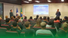 #ParaTodosVerem: imagem de várias pessoas assistindo à apresentação de slides no auditório do campus Santos Dumont