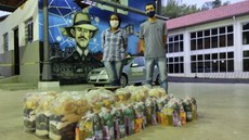 #pratodosverem: Imagem mostra representante do coletivo Manas pelas Minas, Sue Ellen Cruz, e professor Carlos Artur Leal. Eles estão em pé, diante de cestas básicas compradas pelo Instituto Federal com as doações arrecadadas durante o mês de outubro.