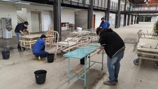 #pratodosverem: Imagem mostra professores e bolsistas trabalhando no reparo de equipamentos hospitalares. Os equipamentos estão espalhados pelo pátio do Bloco 1 do Campus Santos Dumont.