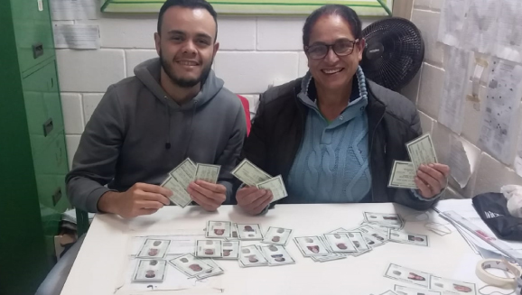 Carteirinhas sendo entregues à diretora da Escola, Déborah de Abreu